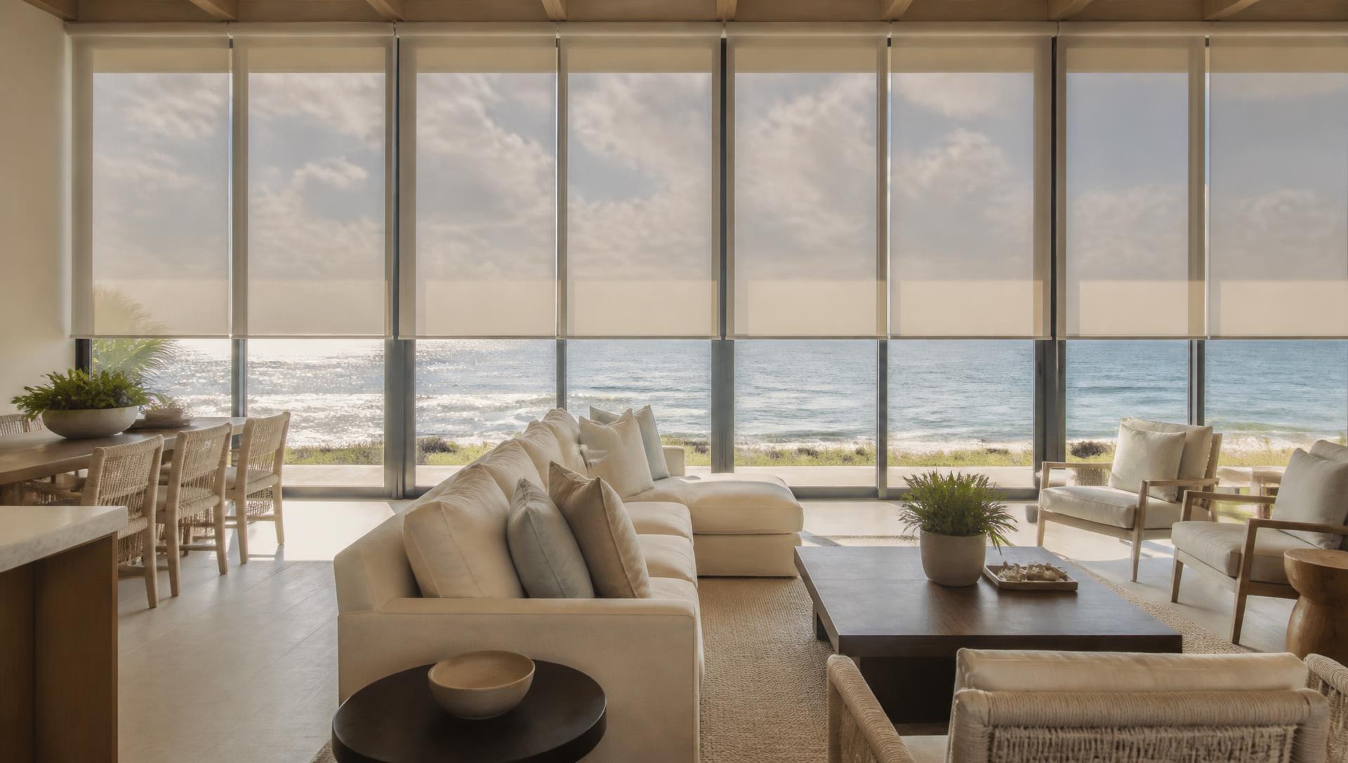 Motorized solar roller shades lowering across a wall of glass in a Gulf-front great room